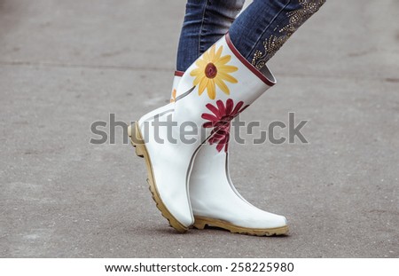 Woman in beautiful gum boots with flowers outdoors