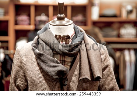 Mannequin in a jacket and scarf in shop.