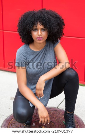 Beautiful young model crouching down on manhole
