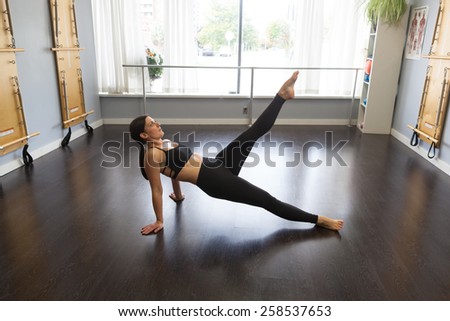 Strong woman doing Pilates floor exercises
