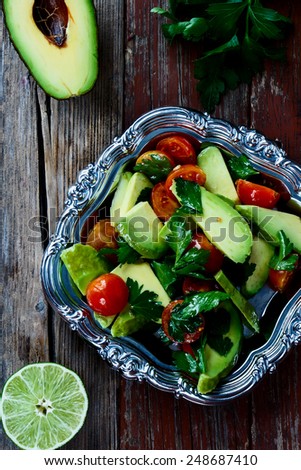 Top view of avocado salad in vintage metal plate - healthy food, diet or cooking concept.
