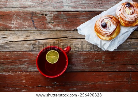 Cup of tea with sweet cake on rustic wooden table. Top view.