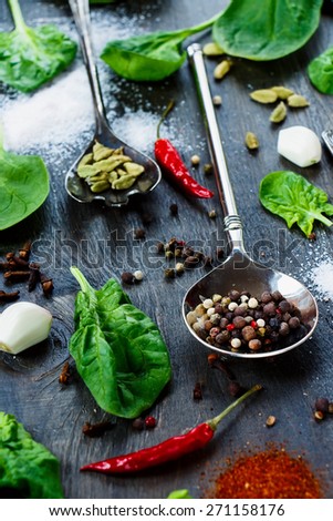 Bright spices and herbs in vintage metal spoons over dark wooden texture - cooking, healthy eating. Selective focus.