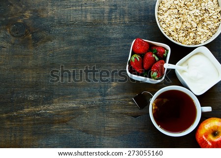 Healthy Breakfast. Oats, berries and tea over dark old wood. Health and diet concept. Top view.