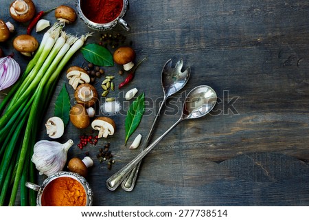 Fresh mushrooms with vegetables and spices on dark wooden table. Background with space for text. Vegetarian food, health or cooking concept.