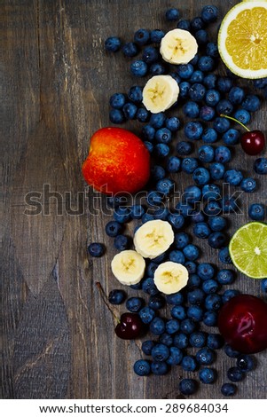 Fruits mix on dark wooden Background. Summer or Spring Organic Fruits. Agriculture, Gardening, Harvest Concept