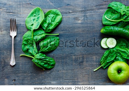 Background with green vegetables over dark wood - detox, diet or healthy food concept.