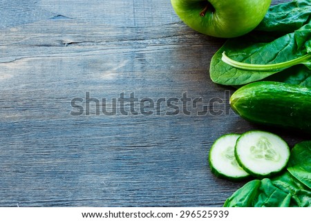 Mix of fresh green vegetables on dark wooden background with space for text. Detox, diet or healthy food concept.