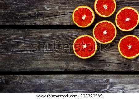 Fresh bio oranges halves fruits on rustic wooden background with space for text.