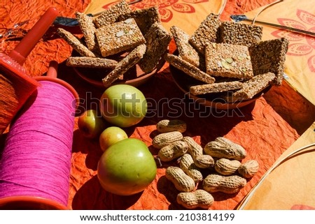 Tasty and crunchy til chikki or Tilkut sesame bars with Indian Green apple jujube ber and whole groundnuts served and eated as tradition culture during sankranti , pongal, lohri, uttarayan festival Stock fotó © 