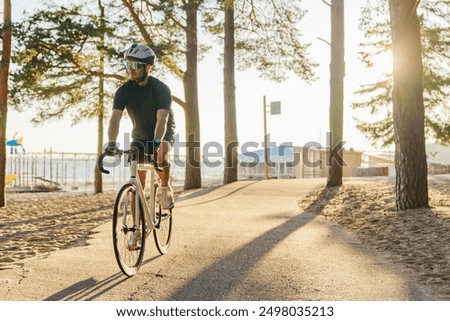 Similar – Image, Stock Photo Man cycling on sandy beach hill