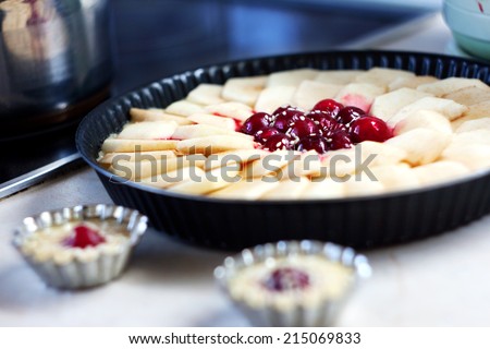 Homemade pie decorated with apple slices and cherries. Cooking delicious homemade pie.