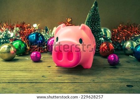 Christmas decoration, piggy  bank  on wooden background, abstract background to time to start to saving or solution for keep money for  celebration.