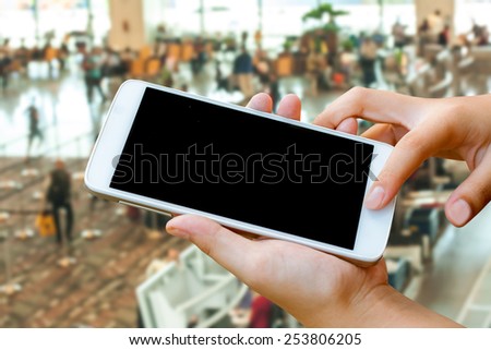 woman hand  hold and touch screen smart phone,tablet,cellphone in the airport terminal