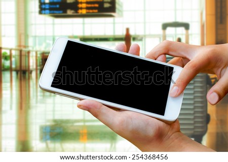 woman hand hold and touch screen smart phone,tablet,cellphone in the airport terminal