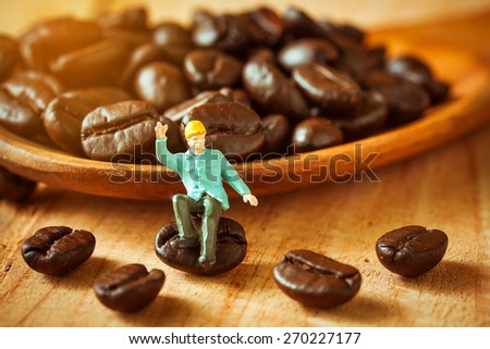 selective focus of miniature worker sitting on coffee bean ,love coffee concept.