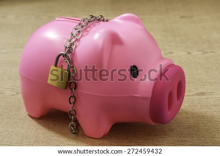 piggy bank with chain lock on wooden background. abstract background for solution to security money saving ,investment ,financial.