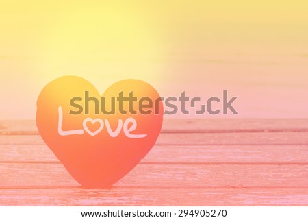 love summer decorate with heart and chalkboard on wooden floor on the blue sea with filter colored.