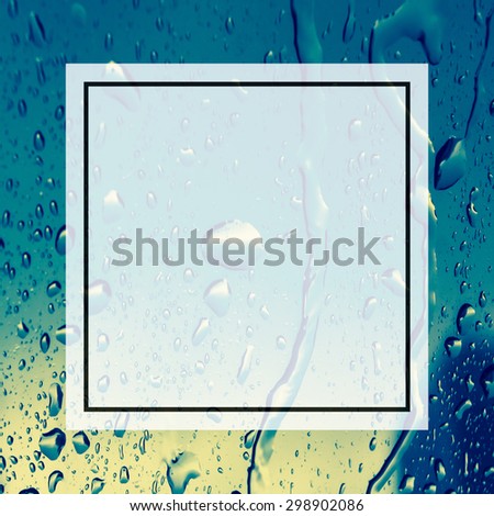 blank design frame label over blurred rain drop on window background,vintage color tone.