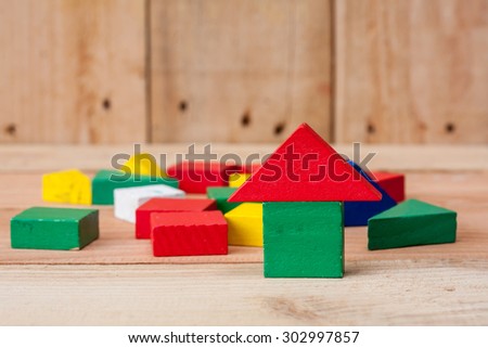 wooden building house block on wooden texture background.