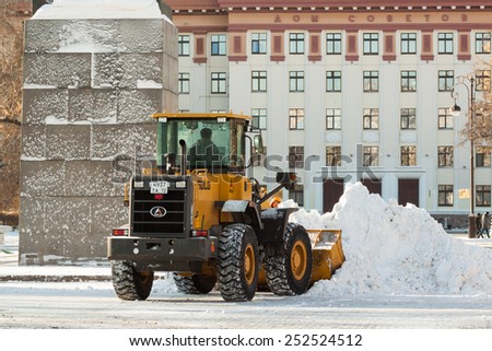Tyumen, Russia - February 12, 2015: Clearing the snow near the byilding of Administration of the Tyumen region. Neighborhood streets Republic.