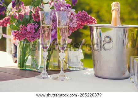 Two glasses of champagne and bottle of champagne in ice bucket.