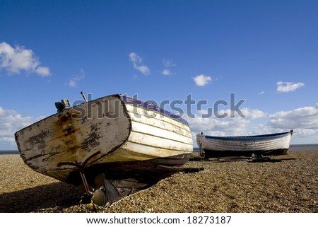 Two old wood hulled coastal fishing boats finish their days on the beach.