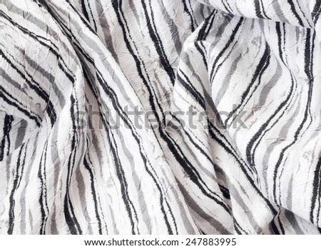 Closeup macro texture of white linen cotton fabric with black grey stripes, clothing background with wrinkles and folds