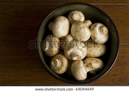 A bird-eye-view of white mushrooms in a bowl.