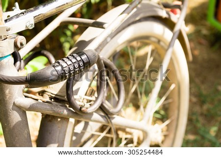 Close up of black bike lock with vintage bike