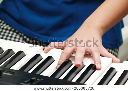 Hands of women on piano keyboard