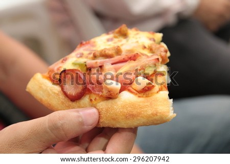 sliced pizza in hand
