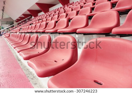 row of red seat in football stadium in perspective