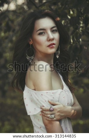 Glamour portrait cute girl in the garden a sunny day field in a white dress