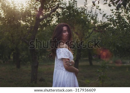 Glamour portrait cute girl in the forest  a white dress, sunshine
