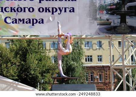 Samara, Russia - August 24, 2014: an unknown girl gymnast performs on stage in Samara, Russia - August 24, 2014. The audience applauded.