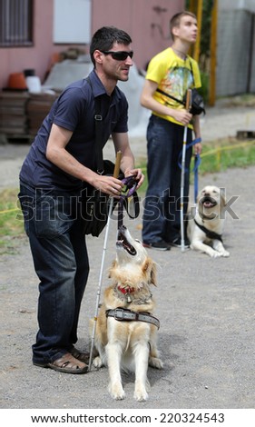 Two blind people with their guide dogs/Sofia, Bulgaria - June 25, 2014: Two blind people are giving commands to their guide dogs as part of dog\'s training.