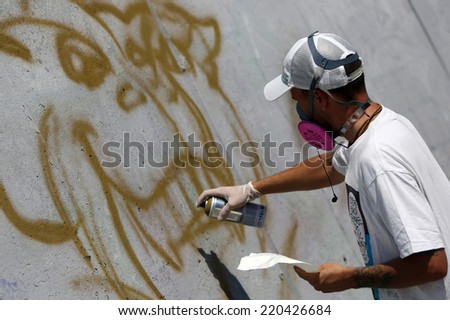 Graffiti artist painting/Sofia, Bulgaria - July 14, 2012: A graffiti artist is painting his artwork on a wall. He is participating in the annual Urban graffiti festival in Sofia.