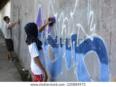 Sofia, Bulgaria - July 14, 2012: A graffiti artist is painting his artwork on a wall. He is participating in the annual Urban graffiti festival in Sofia.