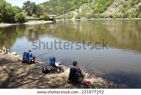Sofia, Bulgaria - May 6, 2012: Three people are fishing on the Pancharevo lake near Sofia. The lake is a popular destination for fishermen.