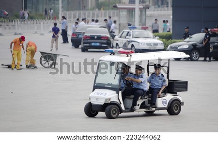 Beijing, China - August 6, 2014: Three Chinese police officers are patrolling in front of a railway station in Beijing.