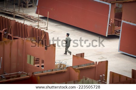 Shenzhen, China - August 6, 2014: Worker at a container cargo harbor is going for his lunch hour.