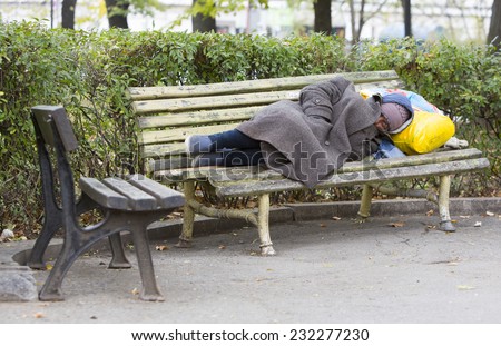 Sofia, Bulgaria - November 4, 2014: Homeless man is sleeping on a bench in the center of Sofia. Years after joining the EU Bulgaria is still the poorest country in the union.