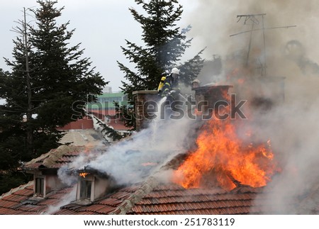 Sofia, Bulgaria - November 24, 2012: Firefighters are extinguishing fire on a burning house roof.