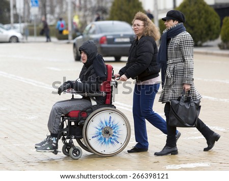 Sofia, Bulgaria - April 3, 2015: A mother and her son are going to a protest with other parents and relatives of physically disabled children and adults against discriminatory state laws.