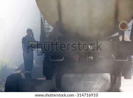 Sofia, Bulgaria - May 19, 2015: Oil tanker train is seen in smoke near Sofia. Fire safety and civil protection service at Fire department is training in a situation of train crash.