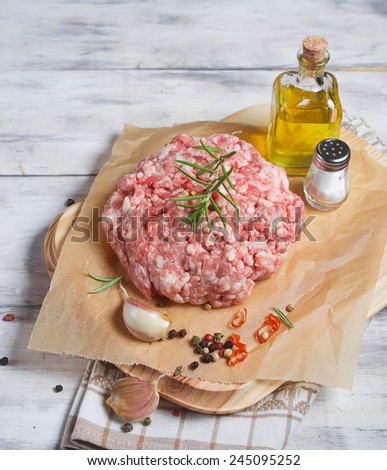 Raw minced meat with pepper, garlic, olive oil and salt on butcher paper