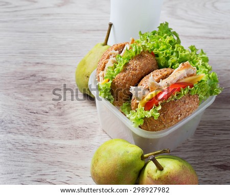 Lunch box with burgers, pears and yogurt. Selective focus