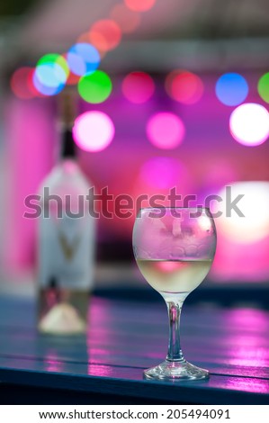 Glasses with wine on the table in the light of lanterns of night club.