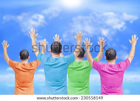 People wearing colorful shirt raising hands over blurred world map of clouds background.  International Volunteers Day concept.